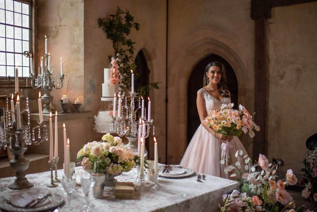 A bride dressed in a pretty pink wedding dress stood inside Bilsington Priory